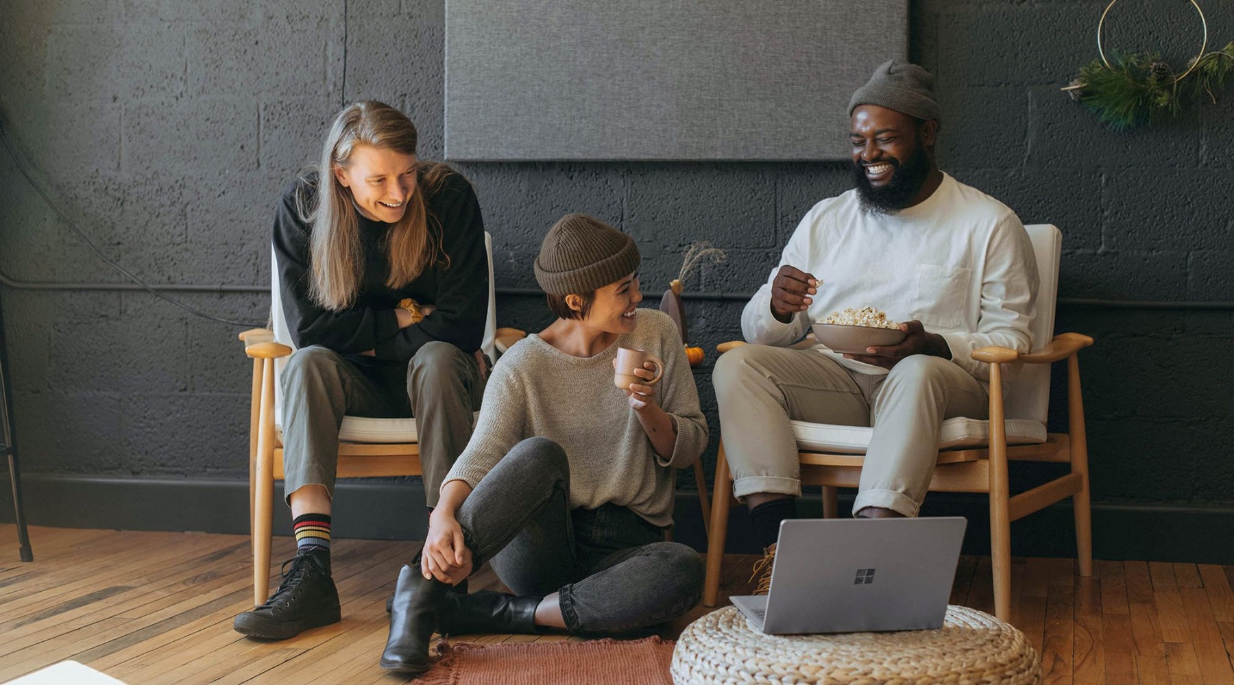 friends sit together around an open laptop